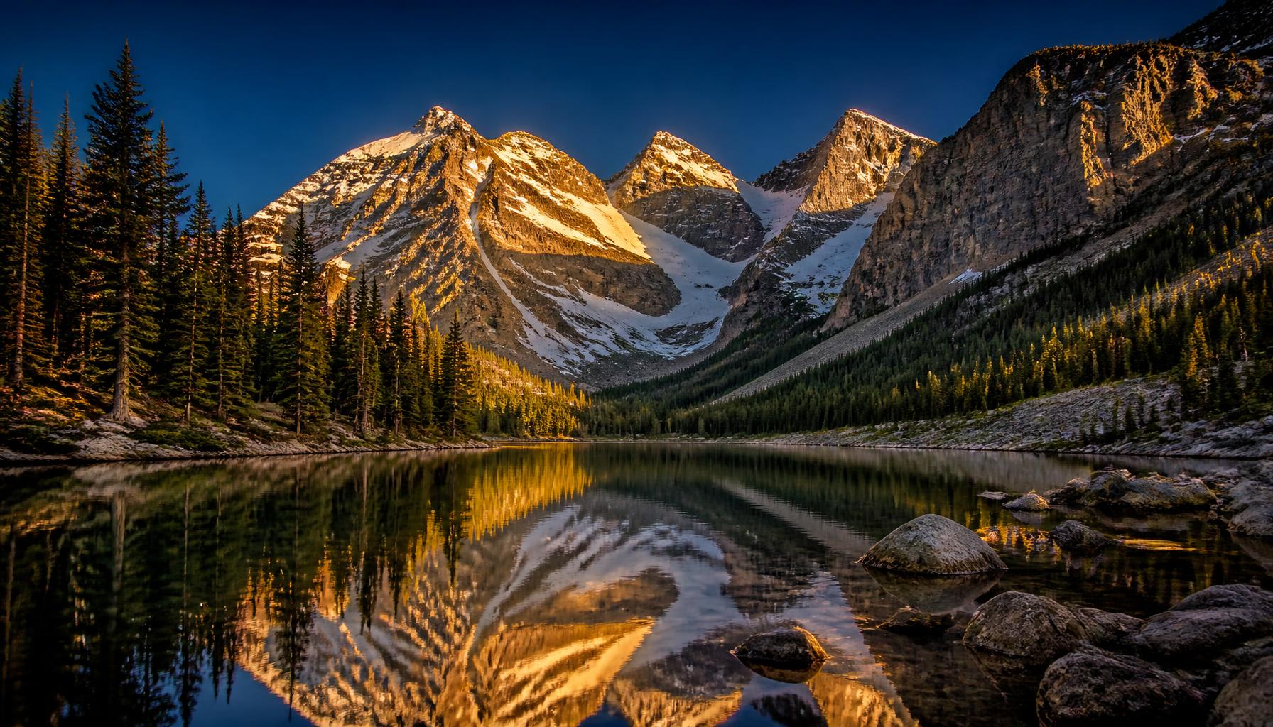 Colorado Rocky Mountains at golden hour reflected in an alpine lake